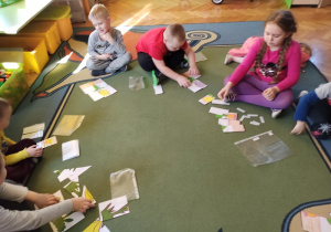 Dzieci układają puzzle i dopasowują nazwy części roślin.